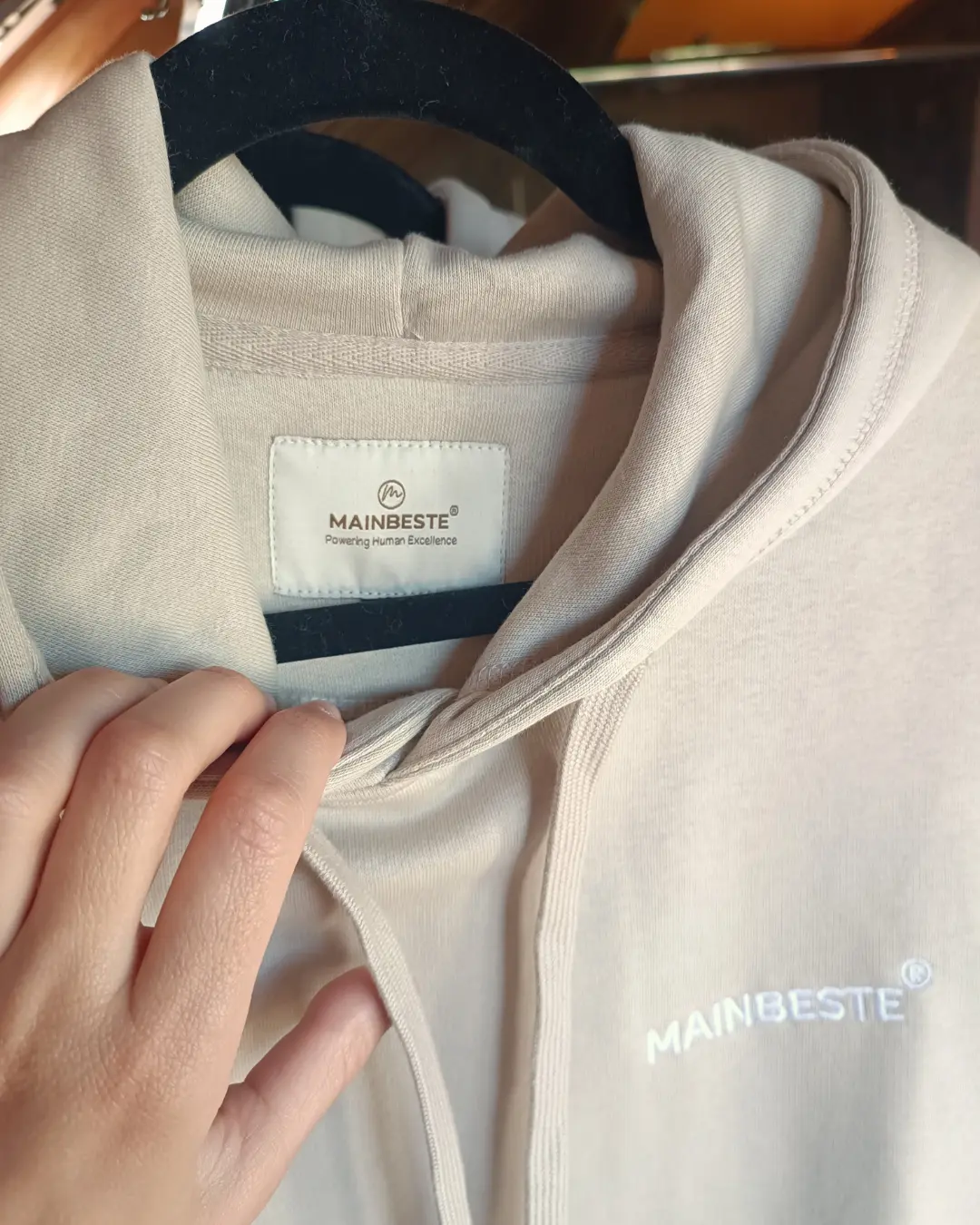 Close-up of Mainbeste hoodie label and embroidered logo
